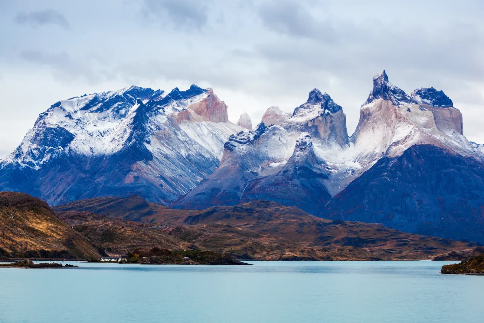 Cuernos del Paine nevados sobre el lago Pehoé, el paisaje que acompaña el trekking W en Torres del Paine